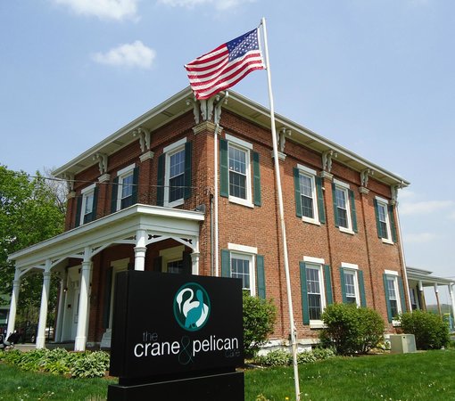 historic red brick house with green shutters