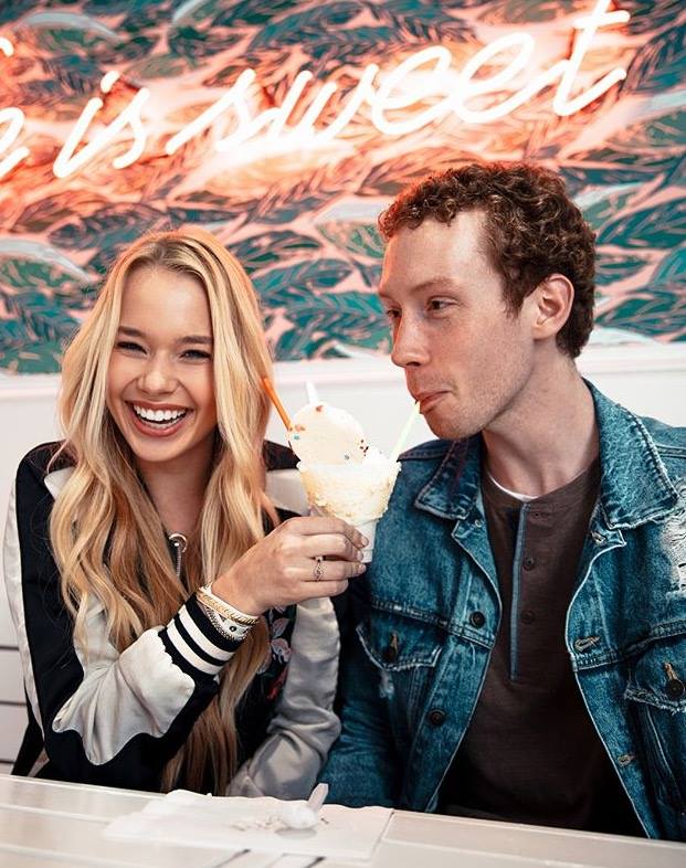 college age man and woman couple sharing an ice cream soda