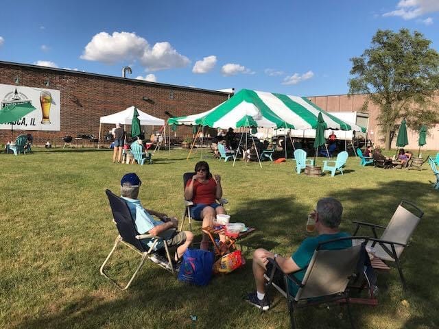 3 people sitting in lawn chairs on the grass