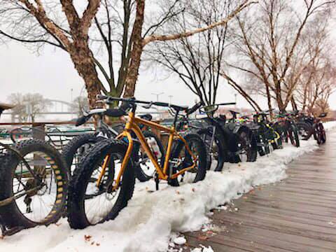 lineup of fat bikes in the snow on patio outside restaurant