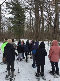 group of people outdoors in winter ready to go snowshoeing