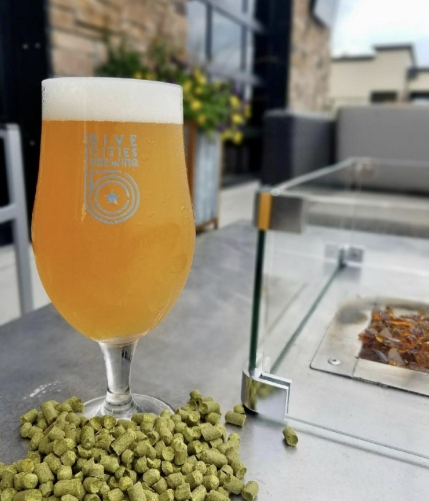 foaming glass of pale beer on patio table