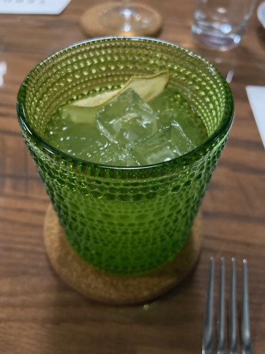 Pera cocktail at Verde: green textured highball glass with a thin sliced pear, ice, and clear liquid