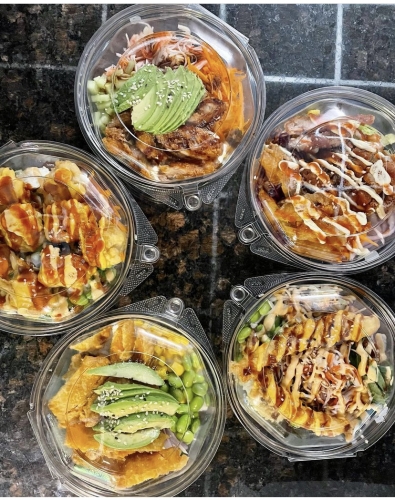 Five round plastic containers filled with orange, white, green, and yellow foods.
