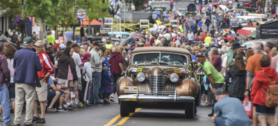 A 1941 Cadillac pulls through a crowd in Fairport, New York.