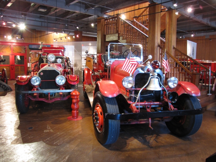 two antique fire trucks on display inside the museum