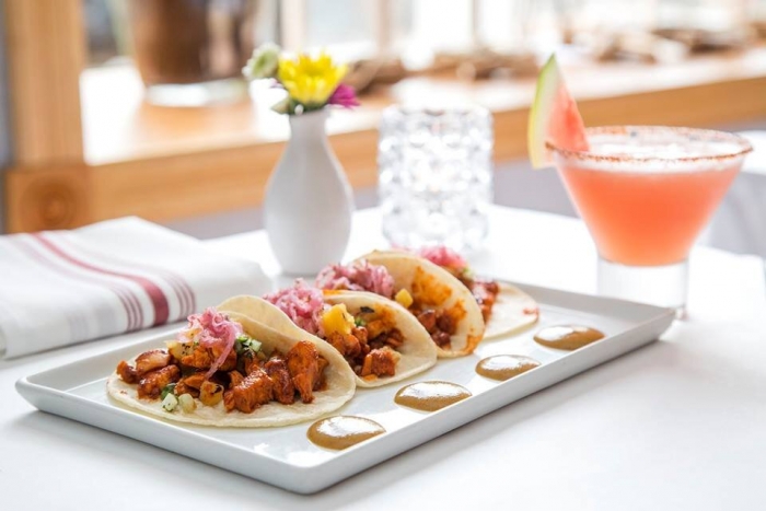 4 street-style tacos on plate with shrimp and watermelon margarita near plate