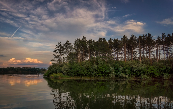 sunset at a lake with trees reflecting in the water