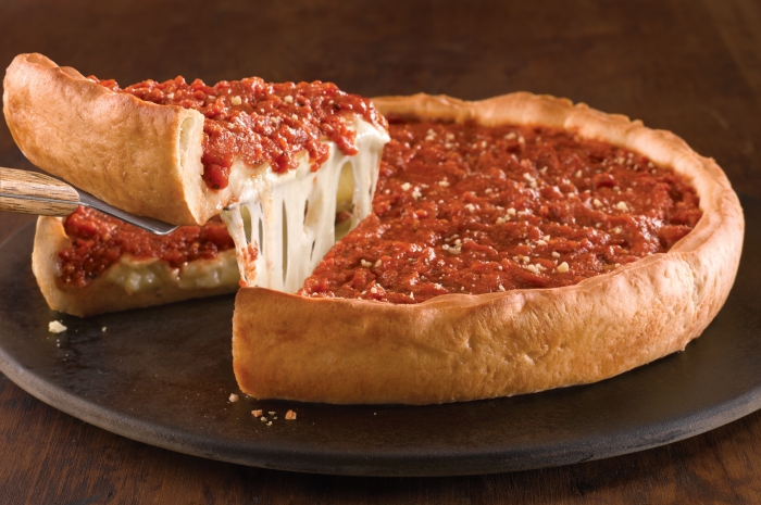spatula lifting a slice of deepdish out from the whole pizza