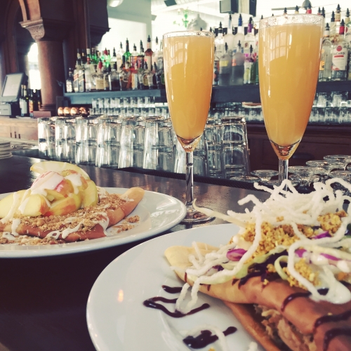 two mimosas sitting on restaurant bar