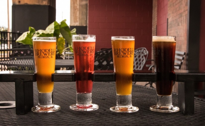 flight of four beers sitting on patio table
