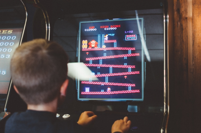 boy playing arcade game