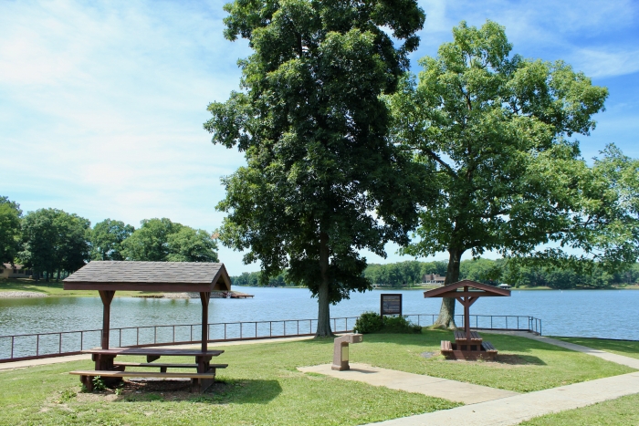 scenic picnic spot with two picnic shelters overlooking lake on sunny day