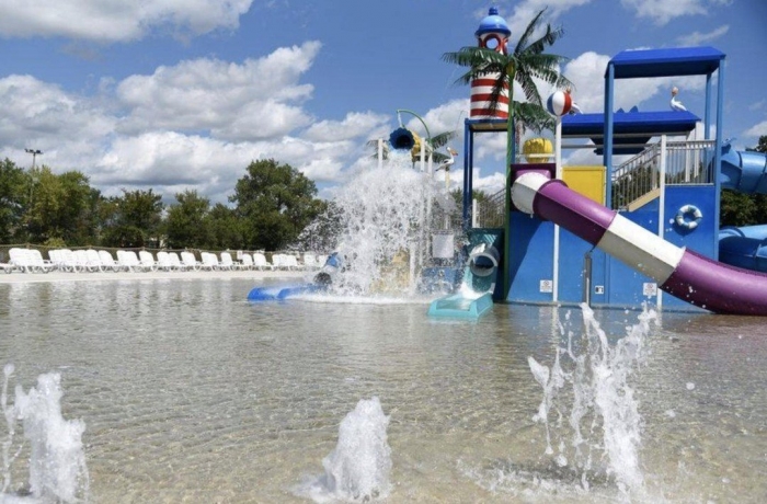 swimming pool with water fountains and water slide and play area
