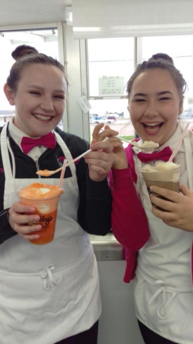 two tennage girl workers hold ice cream shakes