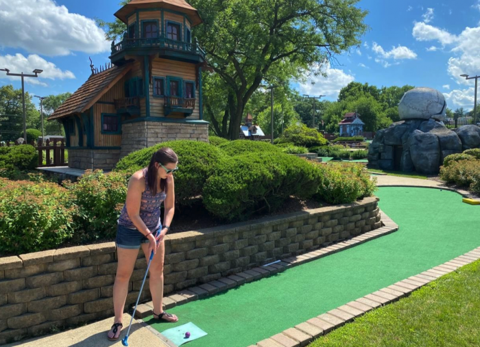 teen girl playing miniature golf