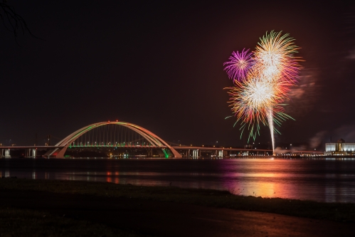 nightime arch bridge with fireworks