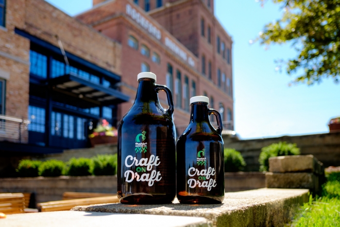 two brown glass growlers sitting on landscape rock