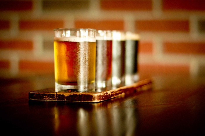 flight of beer in skinny glasses with beer of all shades light to dark