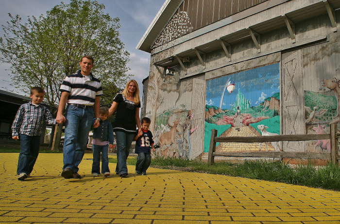 family walking on yellow brick road at petting animal farm