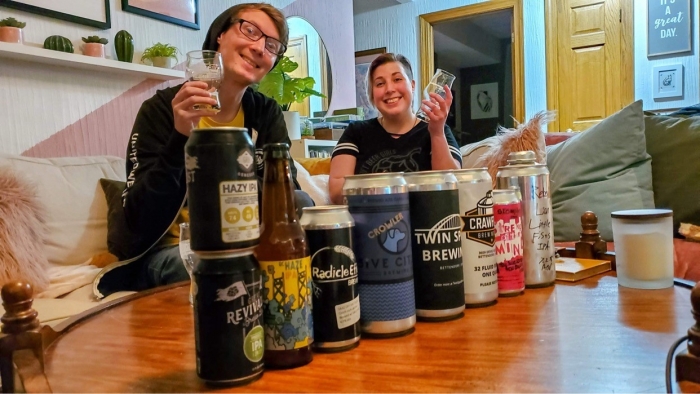 man and woman holding up glasses of pale beer