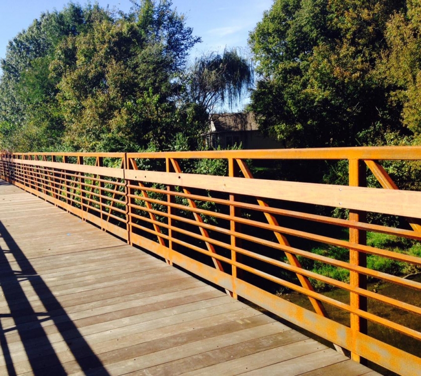 bike path bridge with a decorative orange metal railing