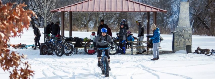 fat biking in winter snow with group by picnic shelter