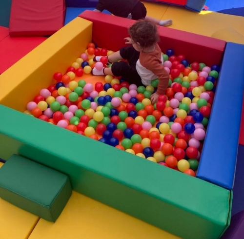 toddler boy playing in colorful ball pit