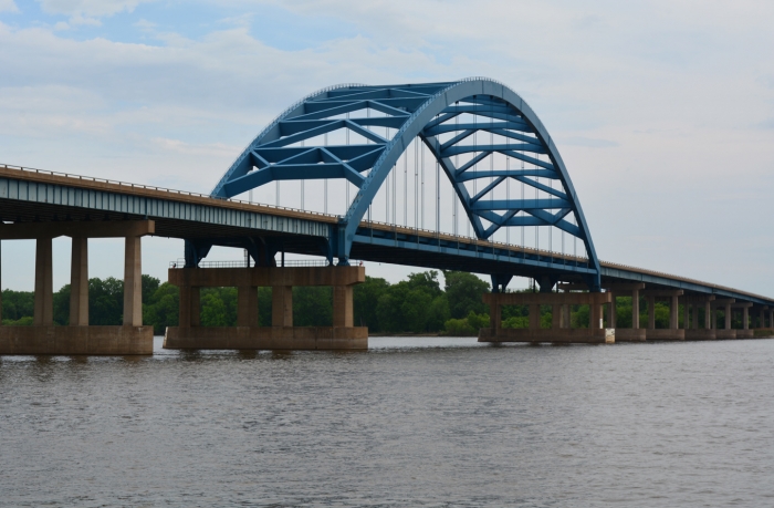 interstate bridge with large blue arch over river