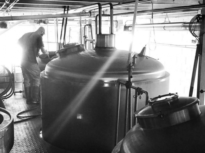 brewer looking a brewing beer tanks