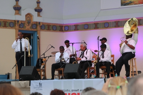 brass band ensemble playing on outdoor bandshell stage