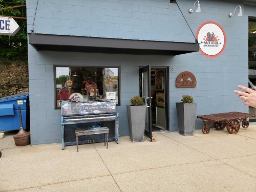 painted piano outside antique store
